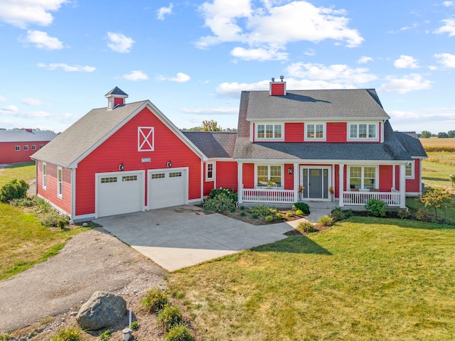 view of front of home featuring a chimney, a porch, concrete driveway, a front yard, and a garage