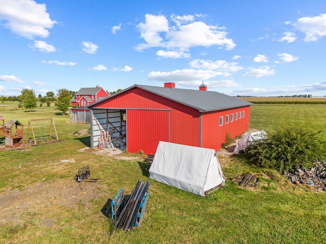 view of outdoor structure with a rural view and a yard