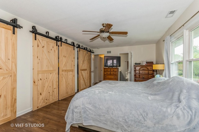 15312 Sunshine Cir, Plainfield, IL 60544 - bedroom featuring a barn door, dark wood-type flooring, baseboards, and a ceiling fan