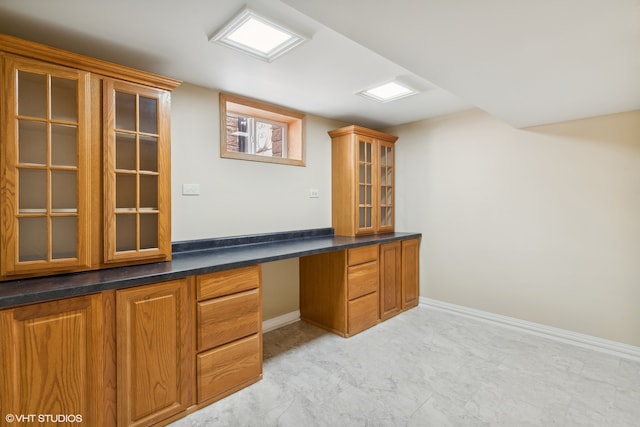 home office with built in desk and light tile patterned floors