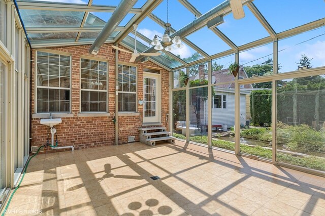 unfurnished sunroom with ceiling fan and a wealth of natural light