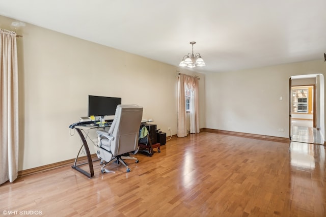 office with an inviting chandelier and light hardwood / wood-style flooring