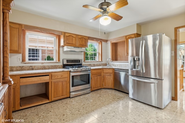 kitchen featuring ceiling fan, decorative columns, appliances with stainless steel finishes, sink, and light tile patterned flooring