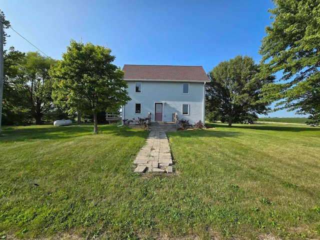 rear view of property featuring a yard