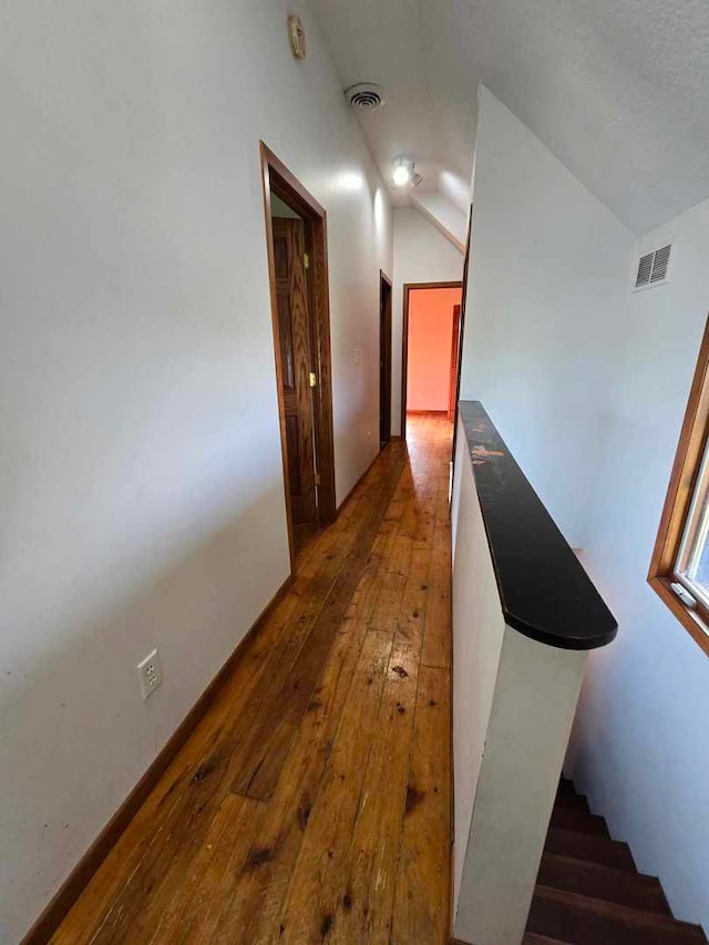 hallway featuring lofted ceiling and dark hardwood / wood-style floors