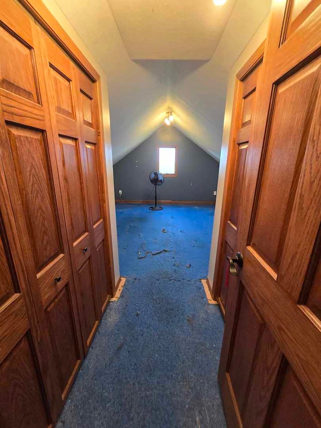 additional living space featuring lofted ceiling and dark carpet