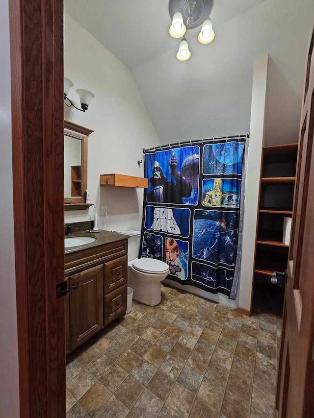 bathroom featuring curtained shower, lofted ceiling, toilet, and vanity