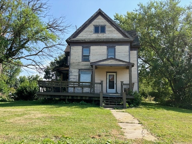 victorian house featuring a deck and a front yard