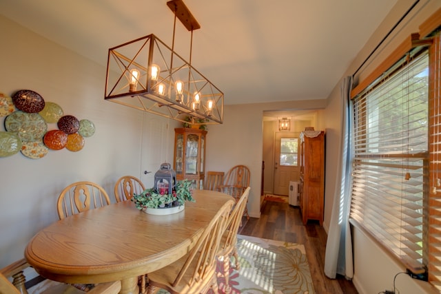 dining area with dark hardwood / wood-style flooring and a notable chandelier