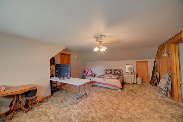 carpeted bedroom with ceiling fan, wooden walls, and lofted ceiling