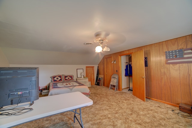 carpeted home office featuring ceiling fan, vaulted ceiling, and wood walls