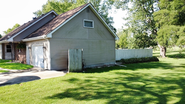 view of home's exterior with a garage and a lawn