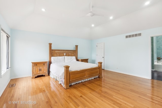 bedroom featuring connected bathroom, lofted ceiling, light hardwood / wood-style flooring, and ceiling fan