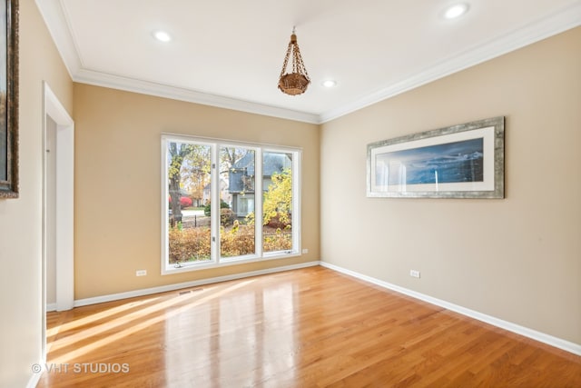 spare room with crown molding and light wood-type flooring