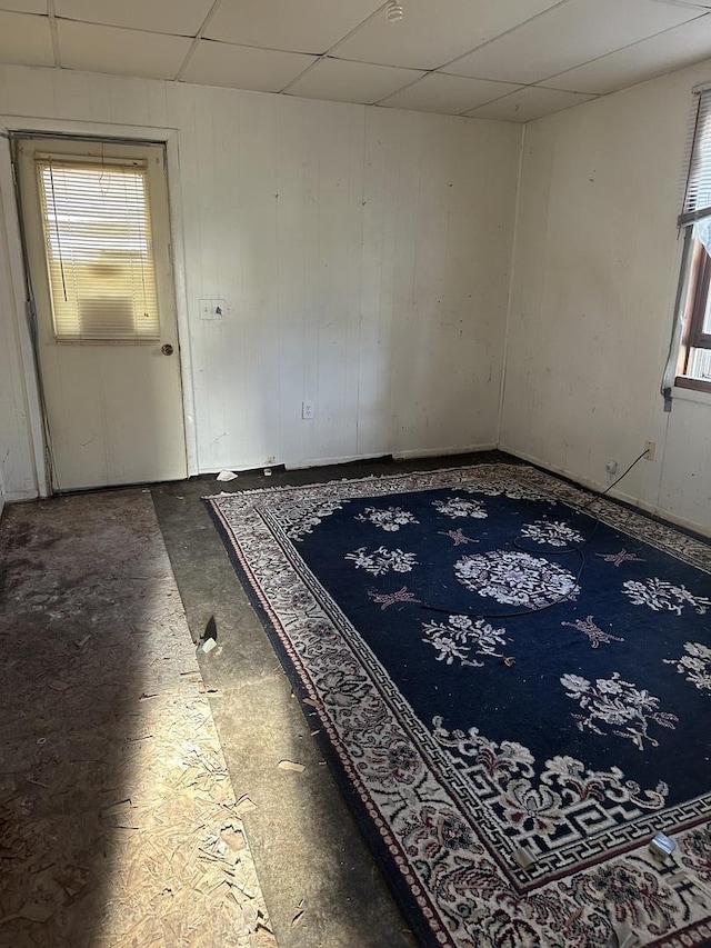 unfurnished room featuring a wealth of natural light and a drop ceiling