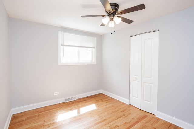 unfurnished bedroom featuring ceiling fan, a closet, and light hardwood / wood-style floors