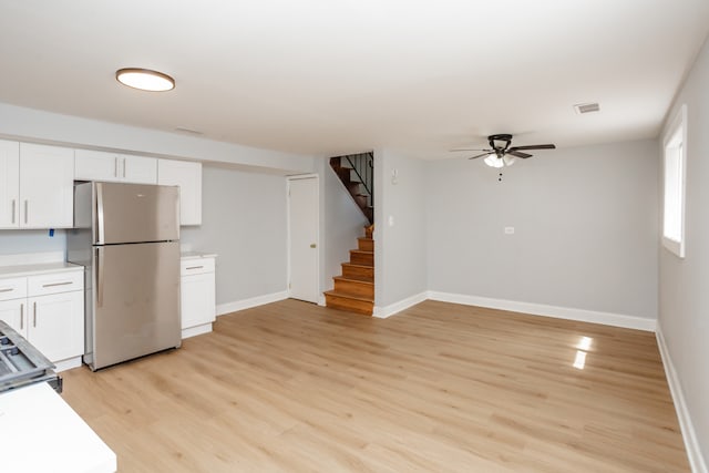 kitchen featuring light wood-type flooring, stainless steel refrigerator, ceiling fan, and white cabinetry