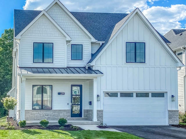 modern inspired farmhouse featuring stone siding, board and batten siding, and a standing seam roof