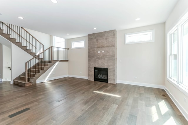 unfurnished living room with recessed lighting, a fireplace, baseboards, and wood finished floors