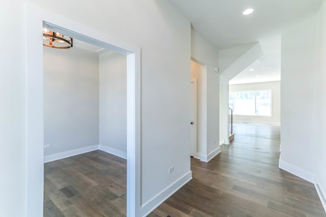 hallway featuring dark wood-type flooring, recessed lighting, and baseboards