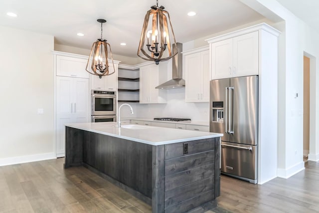 kitchen with stainless steel appliances, a sink, white cabinetry, light countertops, and a center island with sink