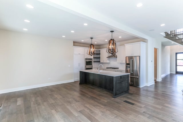 kitchen with light countertops, hanging light fixtures, white cabinets, a kitchen island with sink, and high end refrigerator