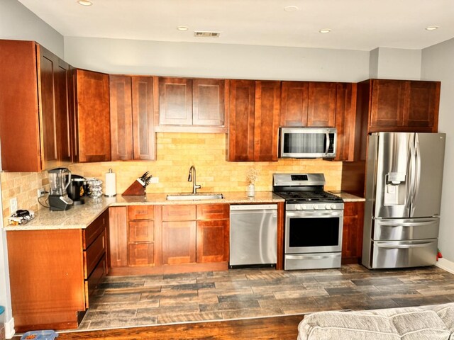 kitchen featuring sink, decorative backsplash, appliances with stainless steel finishes, and dark wood-type flooring