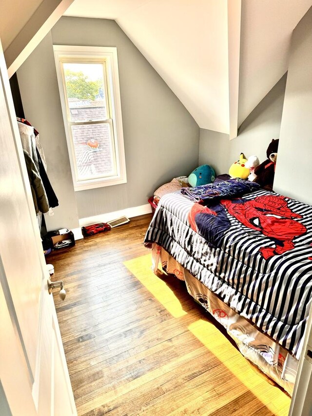 bedroom featuring light hardwood / wood-style flooring and lofted ceiling