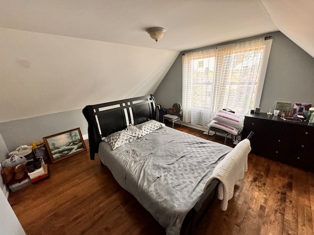 bedroom with vaulted ceiling and hardwood / wood-style flooring