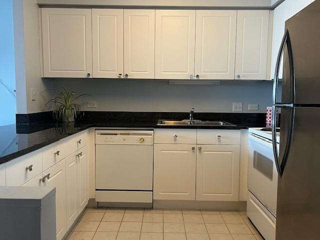 kitchen with white appliances, white cabinetry, and sink