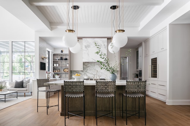 kitchen with light hardwood / wood-style flooring, a breakfast bar, and decorative light fixtures