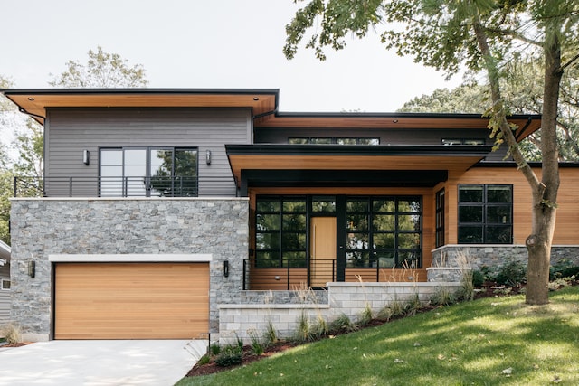 modern home featuring a front yard and a garage