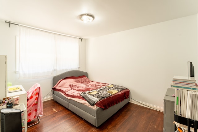 bedroom with dark hardwood / wood-style floors