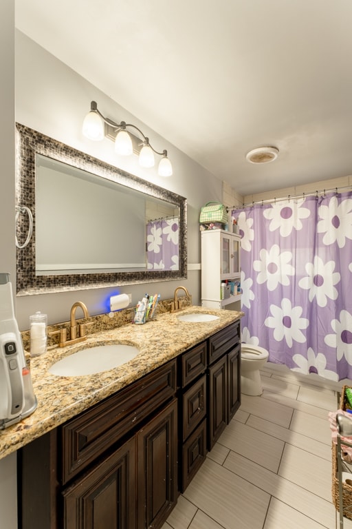 bathroom with tile patterned flooring, toilet, vanity, and a shower with curtain