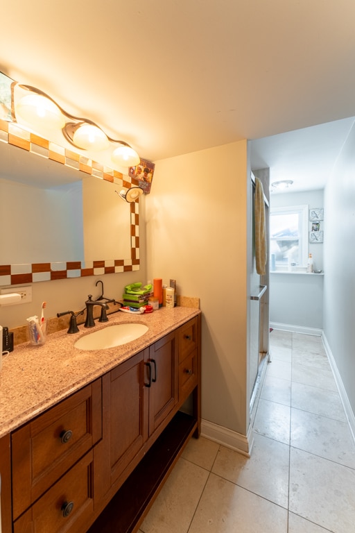 bathroom with tile patterned flooring, an enclosed shower, and vanity