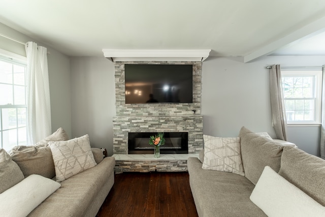 living room with wood-type flooring, beam ceiling, and a stone fireplace