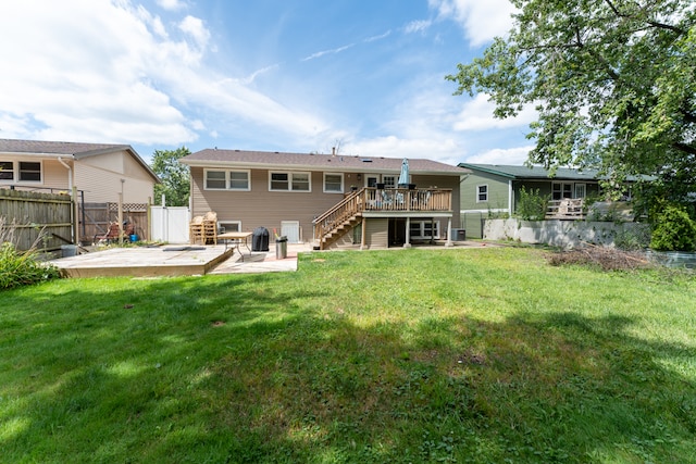 back of property with a yard, a patio area, and a deck