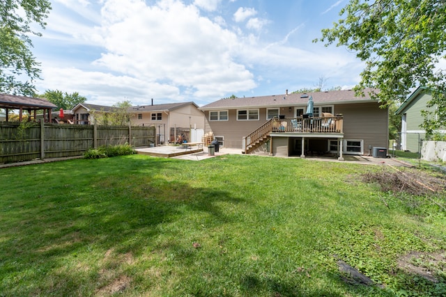 rear view of property featuring a deck, central air condition unit, a patio, and a yard