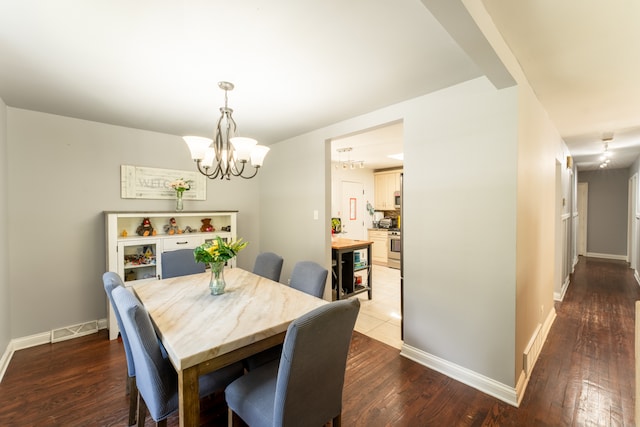 dining room with hardwood / wood-style flooring and a chandelier