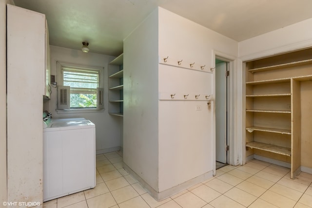 clothes washing area featuring light tile patterned floors and washer and clothes dryer