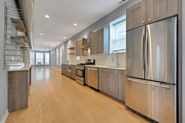 kitchen featuring stainless steel appliances, light hardwood / wood-style flooring, tasteful backsplash, and a healthy amount of sunlight