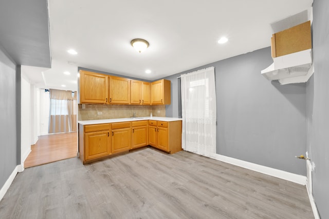 kitchen with light hardwood / wood-style floors and backsplash