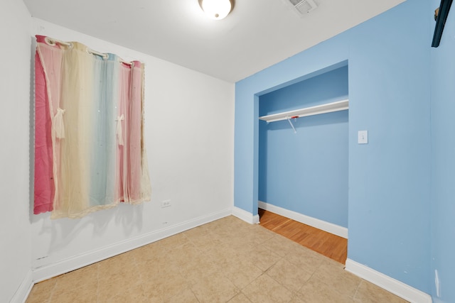 unfurnished bedroom with tile patterned flooring and a closet