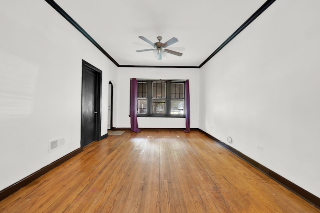 empty room with ceiling fan, crown molding, and hardwood / wood-style floors