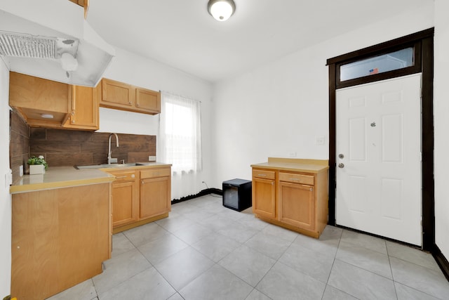 kitchen featuring light tile patterned floors, backsplash, and sink