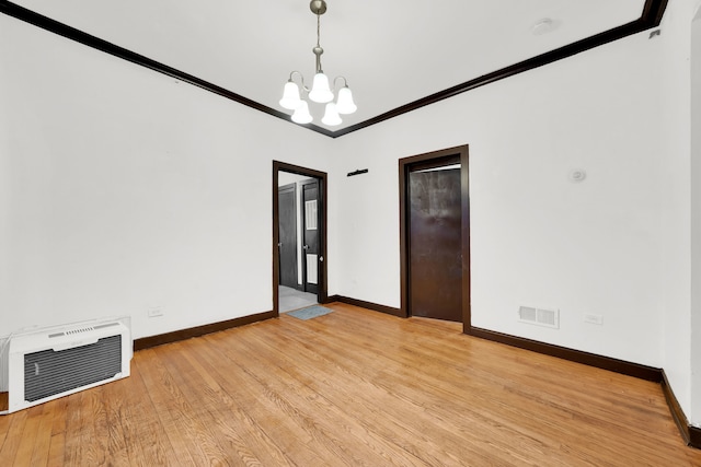 empty room featuring a notable chandelier, light hardwood / wood-style flooring, and crown molding