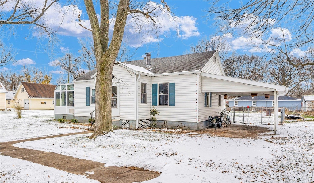 view of front of house with a carport and a sunroom