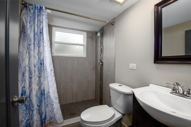 bathroom featuring curtained shower, vanity, and toilet