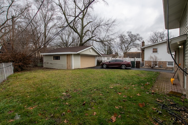 view of yard with a garage and an outbuilding