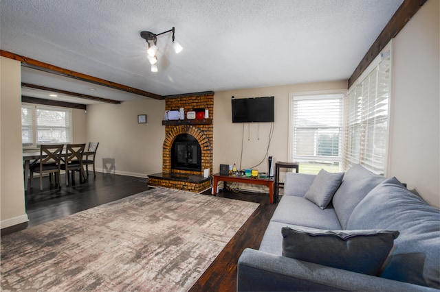 living room featuring a textured ceiling, brick wall, wood-type flooring, and a fireplace